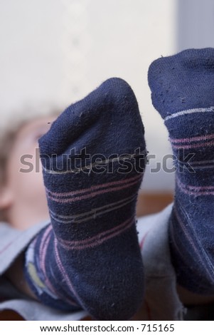 little girl relaxing on a chair with focus on her feet