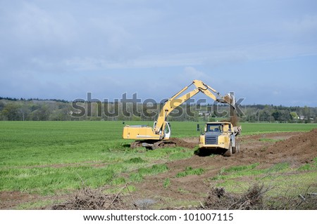 earth-mover dumping earth on a hill