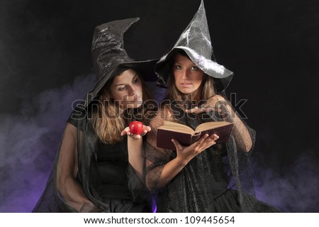 two halloween witches on dark smoky background