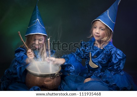 two little halloween witches with cauldron