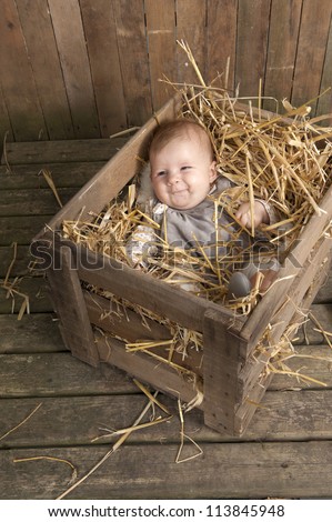 Handle with care ! baby lying in a case with straw