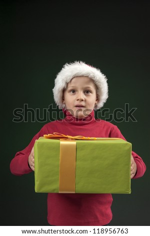 boy with christmas hat and present on dark green background