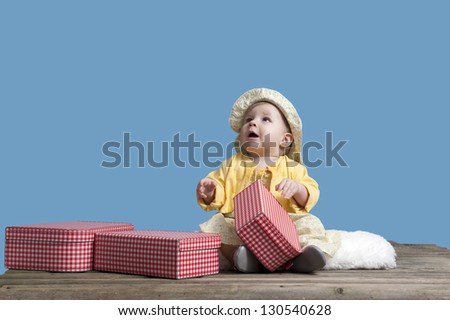 little baby girl with vintage suitcases on an old wooden raft