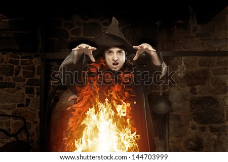 halloween witch casting a spell on dark background