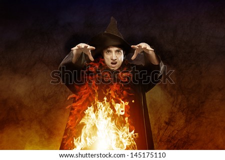 halloween witch casting a spell on dark background