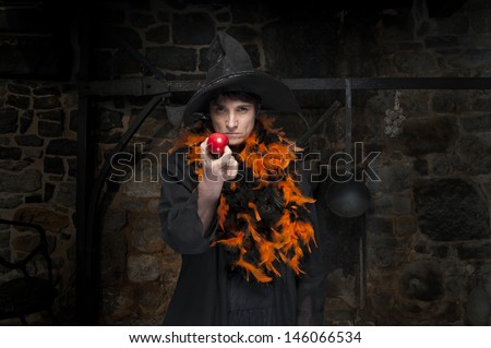 halloween witch with poisoned apple, in an old kitchen