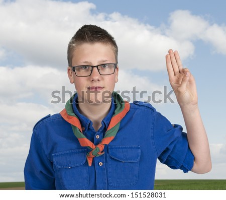 boy scout making an oath swear, outdoors in the fields