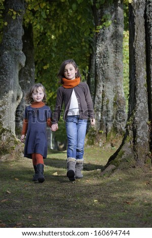 two girls walking on a path in the forest