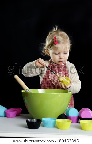 little toddler making deserts, on black background