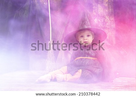 cute little halloween witch with cauldron and smoke
