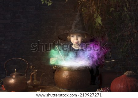 little halloween witch with boiling cauldron