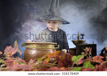 little halloween witch with cauldron and smoke