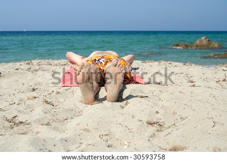adult man sunbathing on the beach