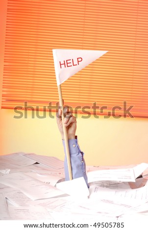 hand with help flag  sticking out of a desk full of papers