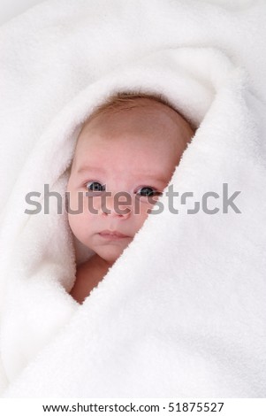 one month old baby wrapped in a white sponge towel
