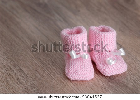 Baby Knitted Booties on Pink Knitted Baby Booties On Wooden Surface  Self Made  Stock Photo