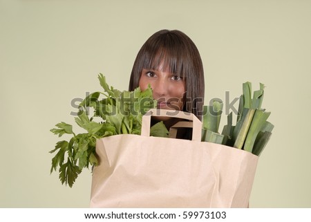 beautiful woman with grocery bag full of vegetables
