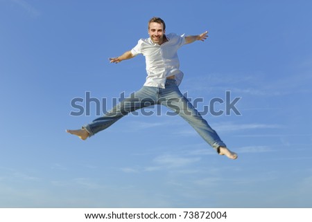 young man jumping in the air against a blue sky