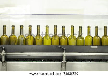 drink industry: empty green glass wine bottles on a filling line