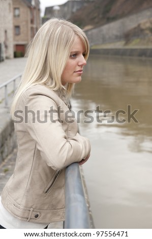 profile of young blonde woman looking at the river
