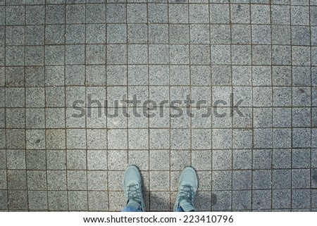 Grey sneakers from an aerial view on grey brick pavement texture, Brick Floor, Top view.