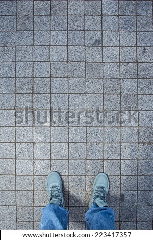 Grey sneakers from an aerial view on grey brick pavement texture, Brick Floor, Top view.
