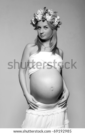 black white pregnant blue eyes blond young woman with bouquet of flowers on her head