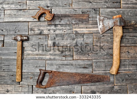 Old working tools. Vintage working tools (drill, saw, ruler and others) on wooden background.