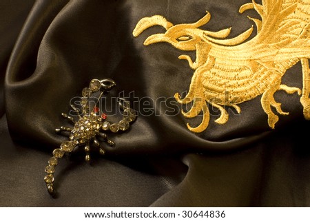 brooch in the form of a scorpion on the traditional Chinese embroidery on black silk