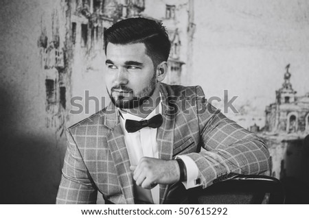 portrait of the groom. groom with beard , big athletic build. sitting on a chair
