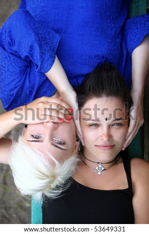 Conceptual photo: a girl closes the other girl ears, the second girl closes the other girl mouth