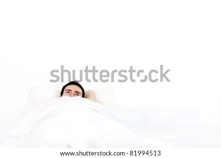 Alone young man in a bed under a white blanket