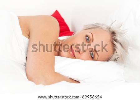 Young beautiful woman lying on the bed, over white