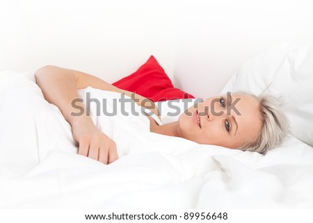 Young beautiful woman lying on the bed, over white