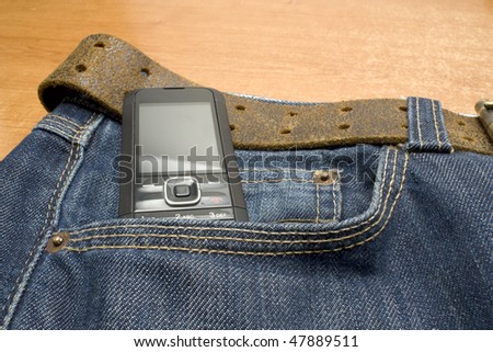 mobile phone in the pocket of a demin jeans