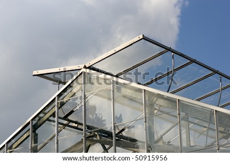 The top of a modern greenhouse, with its glass panels open to let in fresh air