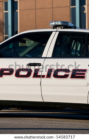 A closeup of the mid-section of a police car, outside of the police station.