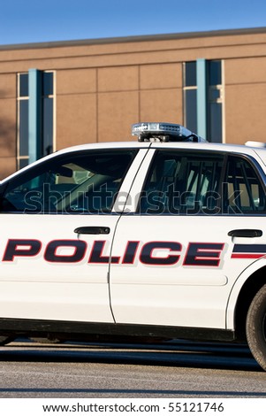 A closeup of the mid-section of a police car, outside of the police station.