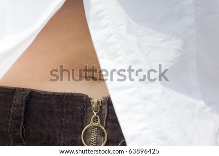 Closeup of a woman\'s mid-section, revealed by an unbuttoned white shirt, showing the belly button.