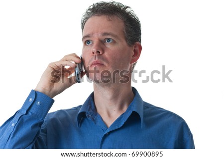 A man in a blue dress shirt, talking on a cellular phone, isolated on white.