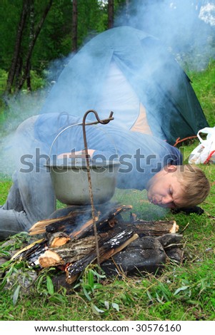 image of the guy planting a fire and tent on the nature