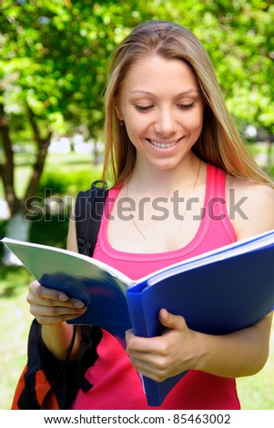 young beautiful woman with the book outdoors