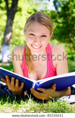 young beautiful woman with the book outdoors