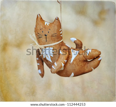 flying brown cat with white drawing and a bow