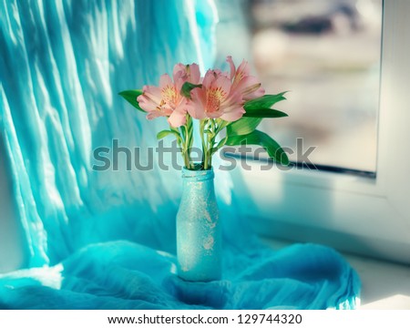 on a blue background and a blue vase delicate ornamental flowers