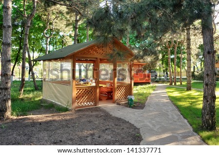 in a pine forest between pine trees in the sunlight wooden gazebo for relaxing