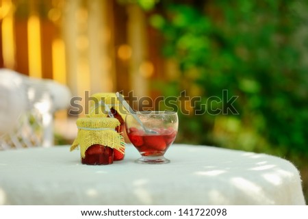 on the nature of the banks on a white table with strawberry jam and a bowl of jam