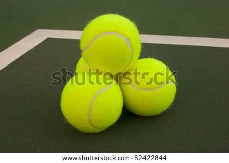 New yellow tennis balls on a green court