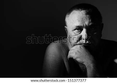Dramatic close up portrait of depressed old man