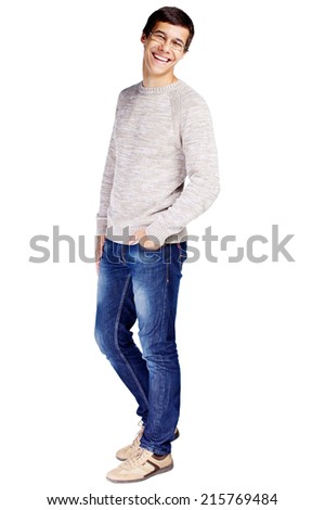 Full length portrait of laughing young man in glasses and beige sweater with hand in his jeans pocket isolated on white background